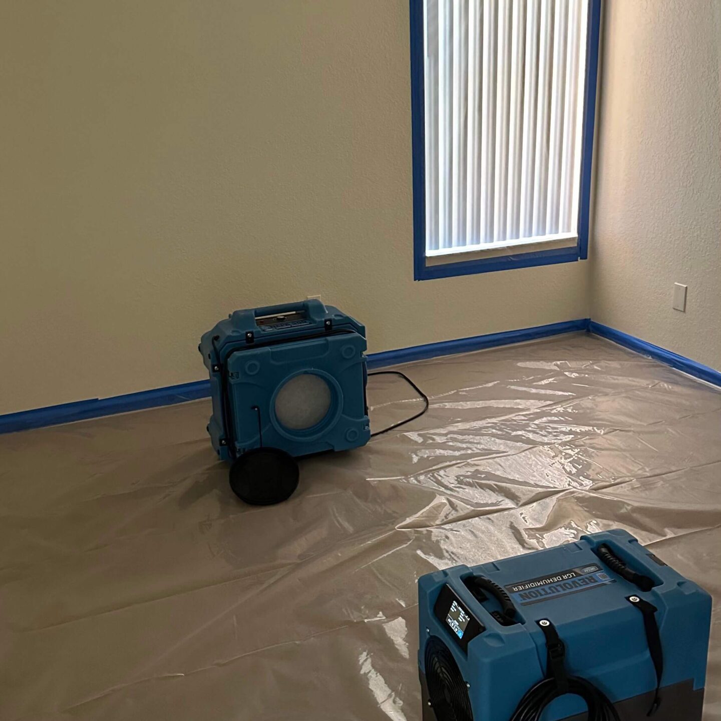 two-machines-in-a-room A room featuring a vacuum and a bucket, prepared for mold cleaning tasks.